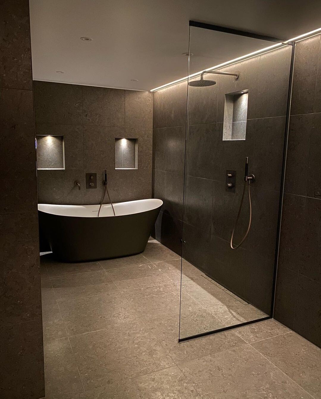 Renoverat badrum: Mörk spa: gråbrun sten, svart fristående badkar, svarta blandare