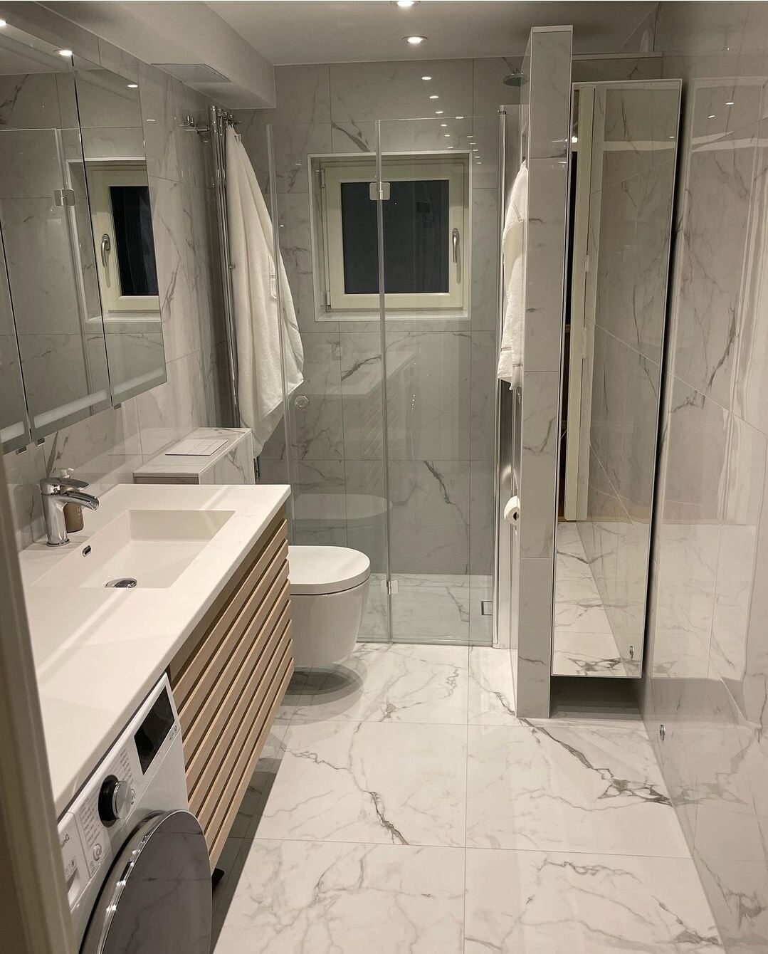 Renoverat badrum: Vit + svart marmor, valnötskommod, tvättmaskin, glasdusch