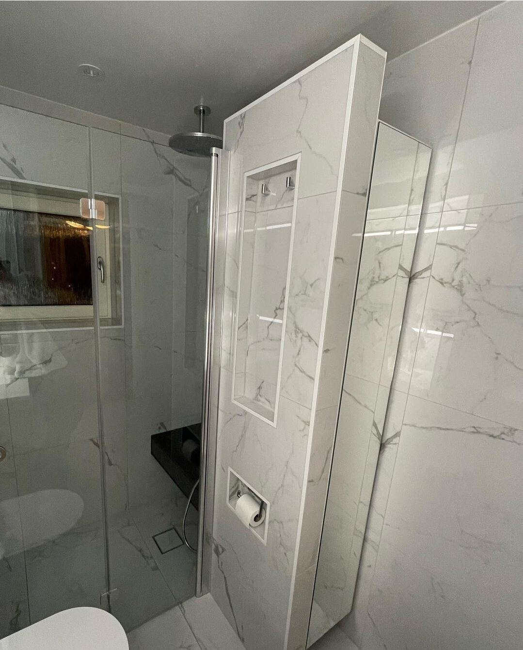 Renoverat badrum: Vit + svart marmor, valnötskommod, tvättmaskin, glasdusch
