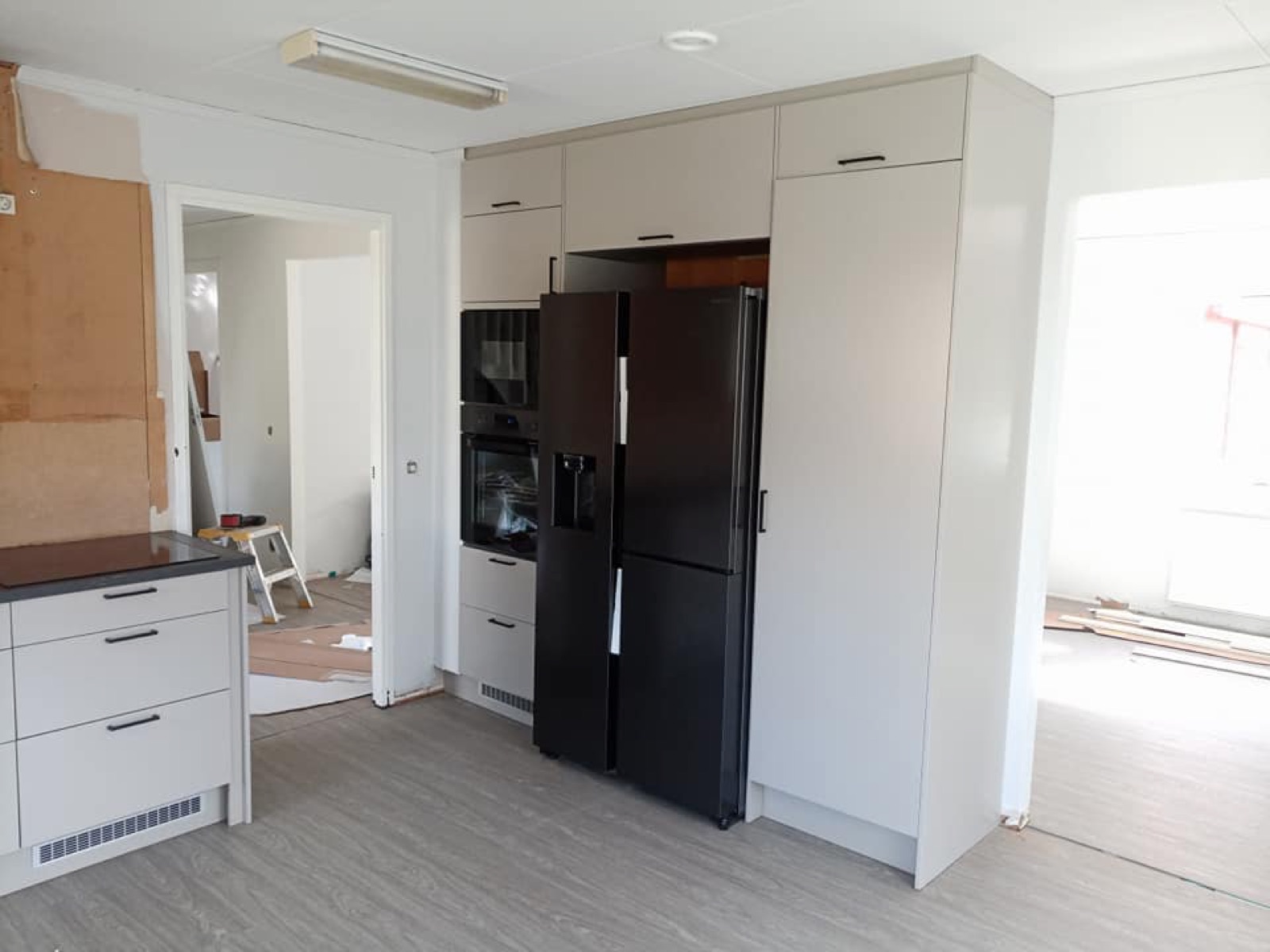 Köksrenovering i Borås, vita luckor och svart kyl